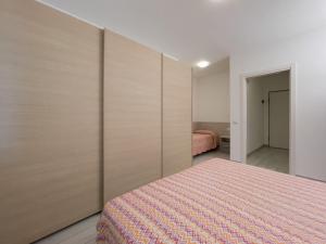 a bedroom with a bed with wooden dividers at Sunbeach Apartments in Lignano Sabbiadoro