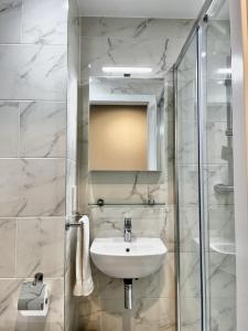 un bagno con lavandino e doccia in vetro di Queen Street Place a Galway