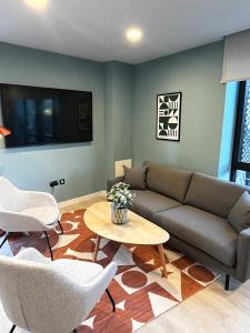 un soggiorno con un divano, sedie e un tavolo di Queen Street Place a Galway