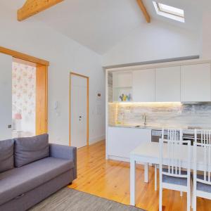 a kitchen and living room with a couch and a table at Charming Apartments in Historic Centre - Inside Porto Apartments "Flores" in Porto