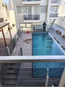 una persona de pie junto a una piscina en un edificio en Centrico loft, en Puerto Madryn