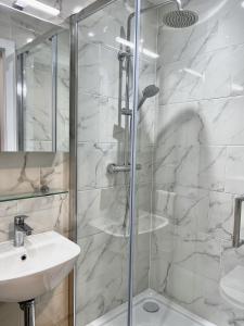 bagno con doccia in vetro, lavandino e servizi igienici di Queen Street Place a Galway