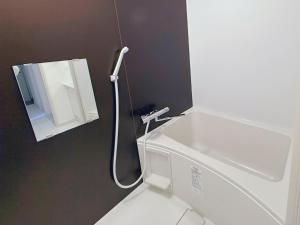 倶知安町にあるNiseko Yotei Vistaの洗面台と鏡のある白いバスルーム