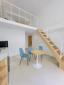 a room with a table and chairs and a staircase at Arista - Thanh My Loi in Ho Chi Minh City