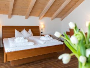 a bedroom with a bed with white sheets and pillows at Hotel Blitzburg in Brunico