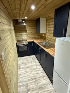 een keuken met zwarte kasten en een witte koelkast bij Stately Stables Camping Site in Winslow