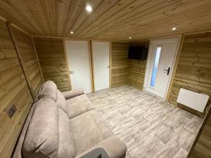 een woonkamer met een bank in een houten kamer bij Stately Stables Camping Site in Winslow