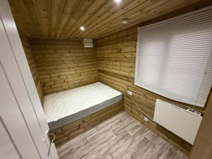 een kleine kamer met een bed in een houten kamer bij Stately Stables Camping Site in Winslow