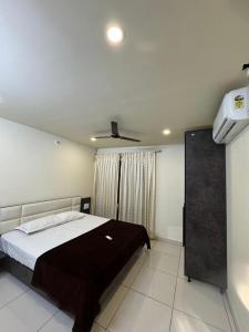 a bedroom with a bed and a ceiling fan at 5BHK AC Villa call 8O882 - 37972 in Mysore
