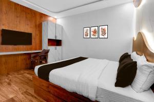 Vānivilāsa PuramHotel O Udaya Residency的卧室里有一张白色的床和一台电视