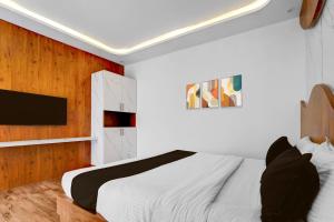 Vānivilāsa PuramHotel O Udaya Residency的卧室里有一张白色的床和一台电视 更多23张照片