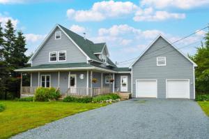 una casa grigia con due porte bianche per il garage di Ocean Surf a Eastern Passage
