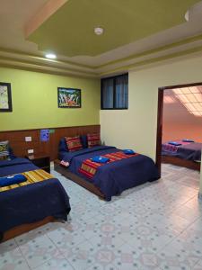a bedroom with three beds in a room at Hostal History in Quito