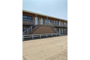 a building with a staircase in front of it at Homestead Inn Wolf Point Hwy 2 in Wolf Point