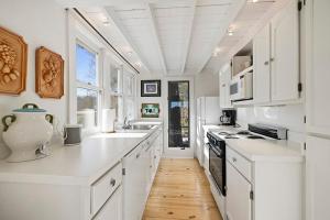 a kitchen with white cabinets and a white counter top at Berrywood Cottage in Lakeside