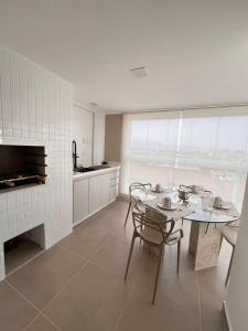 uma cozinha e sala de jantar com mesa e cadeiras em Apartamento a 500m da praia de Bertioga em Bertioga