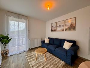 卢登维耶尔Appartement 4 pers à 200m du Skyvall的客厅里有一张蓝色的沙发和一张桌子