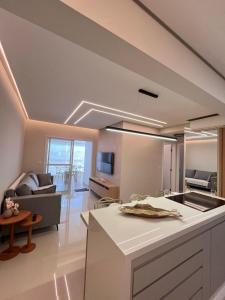 uma cozinha e uma sala de estar com um sofá em Apartamento a 500m da praia de Bertioga em Bertioga