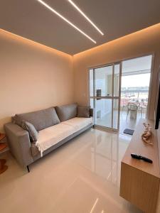 uma sala de estar com um sofá e uma janela grande em Apartamento a 500m da praia de Bertioga em Bertioga mais 28 fotografias