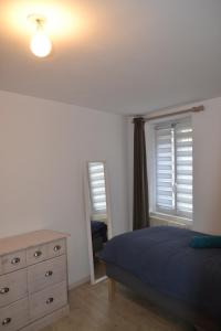 La Blanche des Marais, maison de ville في Picauville: غرفة نوم بسرير وخزانة ومرآة