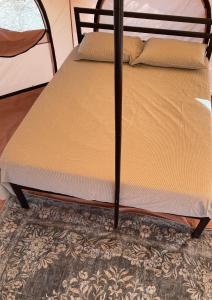 una cama con marco de madera encima de una alfombra en Eco Glamping Biosfera - Bahia Turquesa, en La Ventana 4 fotos más