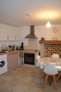 La Blanche des Marais, maison de ville في Picauville: مطبخ مع طاولة وموقد الفرن العلوي +17 صورة