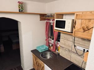 a small kitchen with a sink and a microwave at Chalupa M&P 2 in Bešeňová