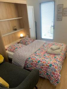 una camera da letto con due letti e una sedia di Le Cocon du Hameau a Bidart