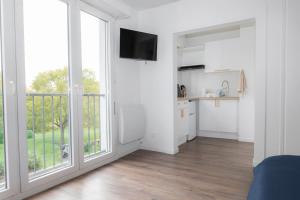 a living room with a kitchen and a large window at Studio le Goya - Cosy & Lumineux in Thionville
