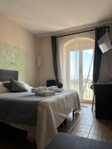 Un dormitorio con dos camas y una gran ventana. en bedbreakfast DINASTIA, en Monterosso Almo