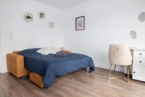 a bedroom with a blue bed and a chair at Studio le Goya - Cosy & Lumineux in Thionville