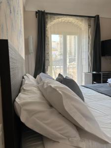 1 cama con almohadas y ventana en bedbreakfast DINASTIA, en Monterosso Almo