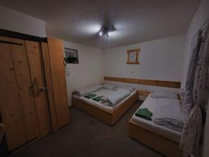 due letti in una piccola stanza con due porte di Chalupa M&P 2 a Bešeňová Altre 6 foto