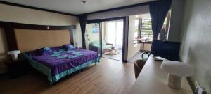 a bedroom with a purple bed and a balcony at Fare Tupaia in Arue