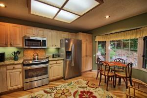 Una cocina con una mesa y un refrigerador de acero inoxidable. en Penrith Hideaway at Yonahlossee, en Boone