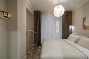 une chambre avec un grand lit et un lustre dans l'établissement Soul Rentals 2BR Cozy Apt, New Block & Calm Gem, à Chişinău