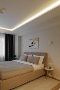 une chambre avec un grand lit et une table dans l'établissement Soul Rentals 2BR Cozy Apt, New Block & Calm Gem, à Chişinău