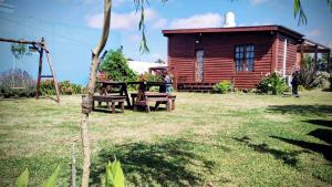 a picnic table in front of a log cabin at ELLA CON El MAR in Mar del Plata +12 photos