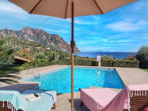 a swimming pool with an umbrella and a view at Villa Sa Perla - Pool, Panoramic View, 250m to Seafront, 650m to Beach in Marina di Gairo