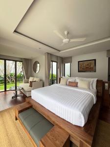a bedroom with a large white bed and a couch at Grand garden villa in Phuket