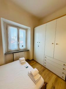 Un dormitorio con una cama con armarios blancos y una ventana. en Luminoso appartamento con garage privato gratuito, en Milán 7 fotos más