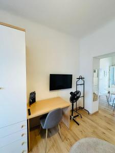 escritorio con monitor y silla en la habitación en Luminoso appartamento con garage privato gratuito, en Milán