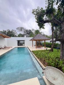a swimming pool in front of a house at Grand garden villa in Phuket
