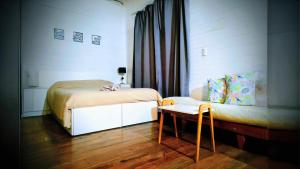 a bedroom with a bed and a couch and a table at ELLA CON El MAR in Mar del Plata