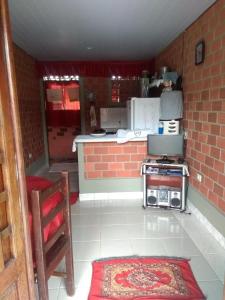 a kitchen with a stove and a brick wall at chalé em Tamandaré in Tamandaré