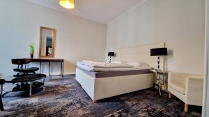 a bedroom with a bed and a desk and a mirror at Kamienica Bankowa Residence in Poznań