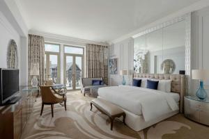 a bedroom with a large white bed and a television at Pik Palace, Shahdag, Autograph Collection in Shahdag