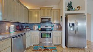 a kitchen with stainless steel appliances and wooden cabinets at Casa Siwichi in Crystal Beach