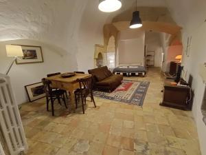 a living room with a table and a couch at In Via Rosario - Ipogeo Holiday Home in Matera