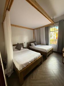 una camera da letto con due letti e una finestra di Cj VILLA a Karatu